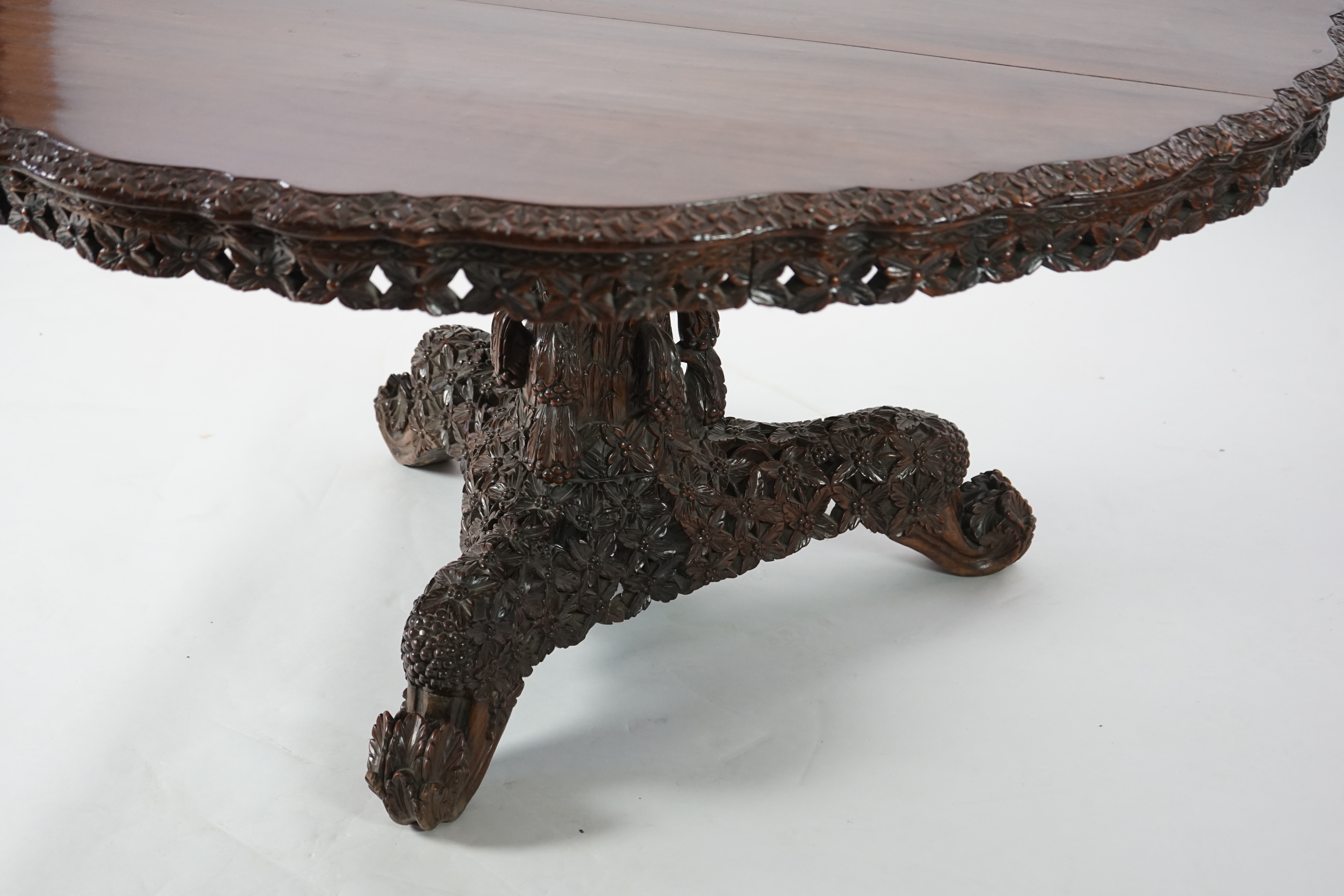 A 19th century Anglo-Indian hardwood foliate carved tilt top centre table